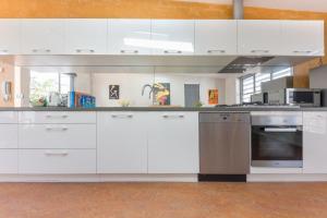 a kitchen with white cabinets and a stainless steel oven at Chic East Sydney Pad in Sydney