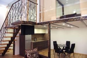 a staircase with a dining room and a table with chairs at Apartment on Tabidze in Tbilisi City