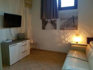een woonkamer met een bank en een flatscreen-tv bij Casa Anna in Specchia