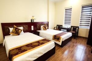 2 łóżka w pokoju hotelowym z 2 oknami w obiekcie Diamond Hotel w Ha Long