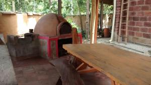 a brick oven with a wooden table in a room at Selvablanca Hostel in San Jerónimo