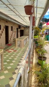 ein Gebäude mit einer Terrasse mit einem Schachbrettboden in der Unterkunft Hill Inn Rooms an HomeStay in Udagamandalam