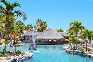 une piscine dans un complexe avec des palmiers et une fontaine dans l'établissement Hotel Palmas De Cortez, à Los Barriles