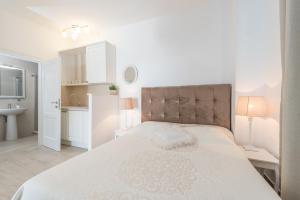 una camera bianca con un grande letto e un bagno di Villa Bella with pool a Novalja (Novaglia)