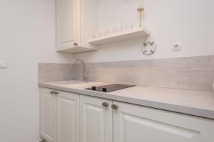 una cucina con armadi bianchi e lavandino di Villa Bella with pool a Novalja (Novaglia) Altre 37 foto