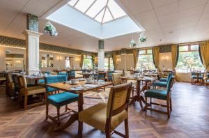 a restaurant with wooden tables and chairs and a skylight at Newby Bridge Hotel in Newby Bridge