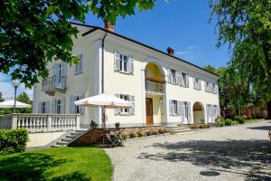 ein großes weißes Gebäude mit einem Schirm davor in der Unterkunft Cascina San Bernardo in Magliano Alfieri