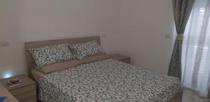 ポルト・チェザーレオにあるLa Casetta a Porto Cesareoのベッドルーム1室(ベッド1台、白黒の掛け布団付)