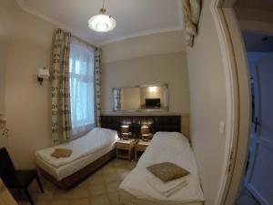 ソポトにあるApartamenty Sopot Centrumのベッド2台、テーブル、鏡が備わる客室です。