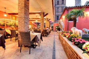 ein Restaurant mit Tischen, Stühlen und Blumen in der Unterkunft New Reiter Hotel in Lido di Venezia