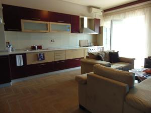 a living room with two couches and a kitchen at Janine's Seafront Apartment in Vlorë