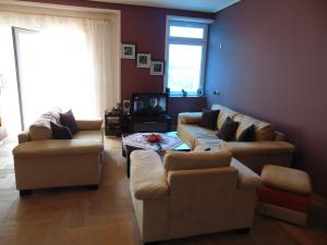 a living room with two couches and a tv at Janine's Seafront Apartment in Vlorë