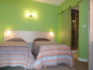 two beds in a room with green walls at Charme Hotel en Beaujolais in Belleville-sur-Saône +16 photos