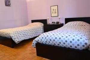 1 dormitorio con 2 camas individuales y suelo de madera en B&B Orio BGY en Orio al Serio