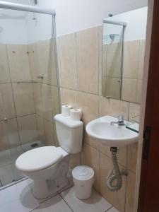 a bathroom with a toilet and a sink at Hostel Vila Carioca in Passa Quatro