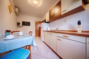 a kitchen with a blue table and a sink at Apartments Marinkovic Komiza in Komiža