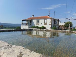 uma grande piscina de água em frente a uma casa em Casas da Loureira - Casa do António e Pascoal em Vila Nova de Cerveira