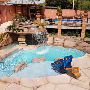 a small pool with a fountain in a backyard at Pousada Nossa Senhora Aparecida in Águas de São Pedro