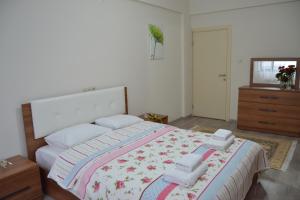 トラブゾンにあるSakura Apartments Trabzonのベッドルーム(大型ベッド1台、ドレッサー付)