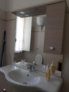 łazienka z umywalką i lustrem w obiekcie San Pietro house w Rzymie +2 zdjęcia
