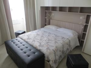 ローマにあるSan Pietro houseのベッドルーム1室(革張りのフットボード付きのベッド1台、ベンチ付)