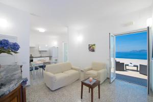 a living room with white furniture and a view of the ocean at My Shazzy with amazing Sea View terrace in Praiano