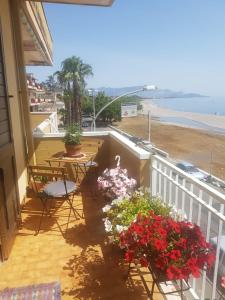 balkon ze stołem, krzesłami i kwiatami w obiekcie Acqua di Mare w mieście Mascali