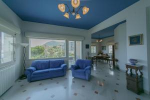 La Terrazza sul Mare في تشفالو: غرفة معيشة مع كرسيين ازرق ونافذة