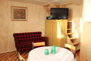 a room with a table and a chair and a television at Cabañas Centenilla in Niebla
