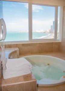 a bathroom with a tub with a view of the ocean at Hotel Almirante Cartagena Colombia in Cartagena de Indias