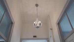 a chandelier hanging in a room with windows at Hostel A Casa da Árvore in Faro