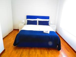 Una cama azul y blanca en una habitación blanca en PortoHouse, en Oporto