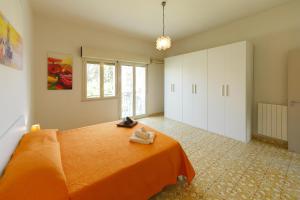 チェファルにあるLa Terrazza sul Mareのベッドルーム1室(オレンジのシーツが付いたベッド1台付)