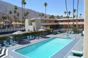 a swimming pool with chairs and a hotel at Musicland Hotel in Palm Springs