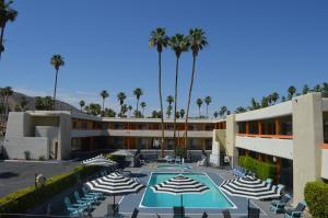 a resort with a pool and chairs and palm trees at Musicland Hotel in Palm Springs