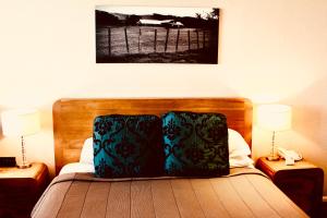 um quarto com uma cama com uma cabeceira de madeira e 2 candeeiros em The Nautilus em Napier