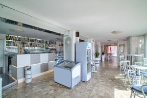 um restaurante com um bar com mesas e cadeiras em Hotel Sanremo em Caorle