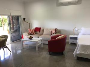 uma sala de estar com um sofá e uma mesa em Hideaway on Hillview em Cairns