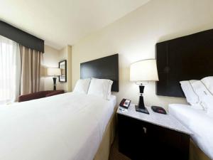 Habitación de hotel con 2 camas y escritorio con lámpara. en Holiday Inn Express-International Drive, an IHG Hotel, en Orlando
