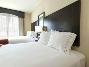 um quarto de hotel com duas camas com almofadas brancas em Holiday Inn Express-International Drive, an IHG Hotel em Orlando