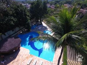 an overhead view of a swimming pool with a palm tree at Canto do mar Maresias in Maresias