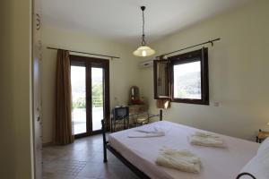 a bedroom with a bed with two towels on it at Villa Platanaki in Kerveli