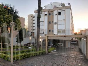 a gate in front of a building with a tree at Apartamento Jardim Botânico 3 quartos 3 vagas para carro in Porto Alegre