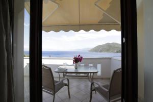 a table and chairs on a balcony with a view of the ocean at Villa Platanaki in Kerveli
