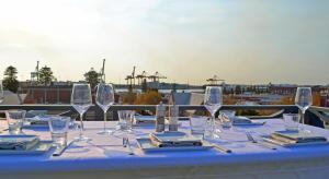 a table with wine glasses and napkins on a balcony at The National Hotel in Fremantle