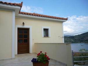 a white house with a door and a flower pot at Villa Platanaki in Kerveli