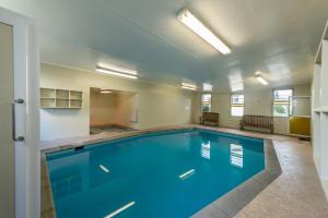 a swimming pool with blue water in a building at Amber Court Motel in New Plymouth