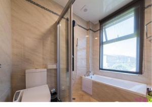 un bagno con vasca, lavandino e finestra di Manman B&B a Dayin