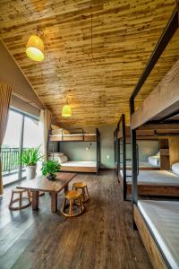 a room with two bunk beds and a wooden ceiling at Lustig Hostel in Sapa