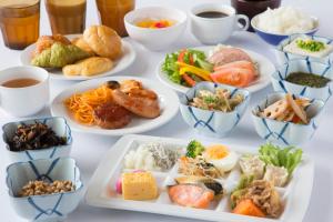 una mesa con muchos platos de comida. en Hotel Super Tomari, en Fujieda